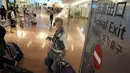 Salah satu wisatawan  asing berjalan setibanya di Bandara Internasional Haneda, Tokyo, Selasa (11/10/2022). Jepang termasuk negara yang mempertahankan beberapa tindakan perbatasan paling ketat di antara negara-negara ekonomi utama sejak awal pandemi. (AP Photo/Eugene Hoshiko)
