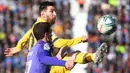 Gelandang Barcelona, Lionel Messi, berebut bola dengan gelandang Leganes, Javier Eraso, pada laga La Liga Spanyol di Estadio Municipal Butarque, Leganes, Minggu (23/11). Leganes kalah 1-2 dari Barcelona. (AFP/Pierre-Philippe Marcou)