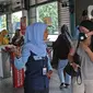 Petugas memberi informasi ke penumpang cairan pembersih di halte transjakarta Cawang UKI, Jakarta, Selasa (3/3/2020). PT Transportasi Jakarta (TransJakarta) menyiapkan cairan pembersih tangan (hand sanitizers) di 80 halte untuk mencegah penyebaran virus corona. (Liputan6.com/Herman Zakharia)