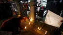 Seorang wanita meletakkan lilin di lokasi bom bunuh diri di Sultanahmet Square, Istanbul, Rabu (13/1). Bunga dan lilin tersebut wujud belasungkawa untuk korban ledakan di Turki. (REUTERS/Osman Orsal)