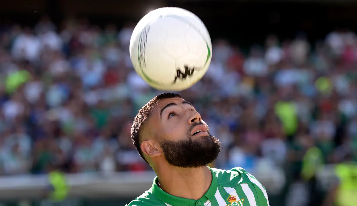 Gelandang asal Prancis, Nabil Fekir mengontrol bola dengan kepalanya selama presentasi resmi dirinya sebagai pemain baru Real Betis di stadion Benito Villamarin di Seville (6/8/2019). Fekir direkrut Betis dengan harga 20 juta euro atau sekitar 312 miliar rupiah. (AFP Photo/Cristina Quicler)
