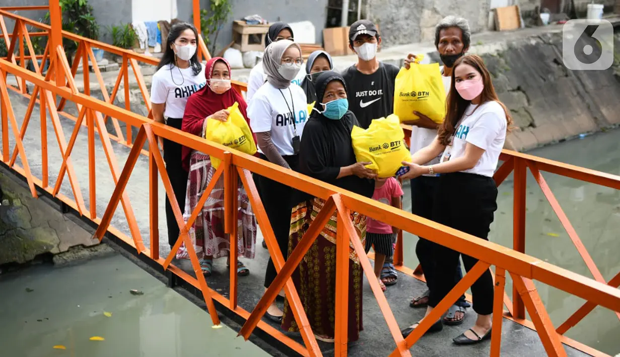 Karyawan milenial Bank BTN membagikan bantuan paket sembako kepada masyarakat kurang mampu di kawasan Menara Bank BTN di Jakarta, Senin (11/4/2022). Ratusan paket sembako tersebut merupakan komitmen BTN dalam mendukung tercapainya pemenuhan hak dasar manusia. (Liputan6.com/HO/BTN)