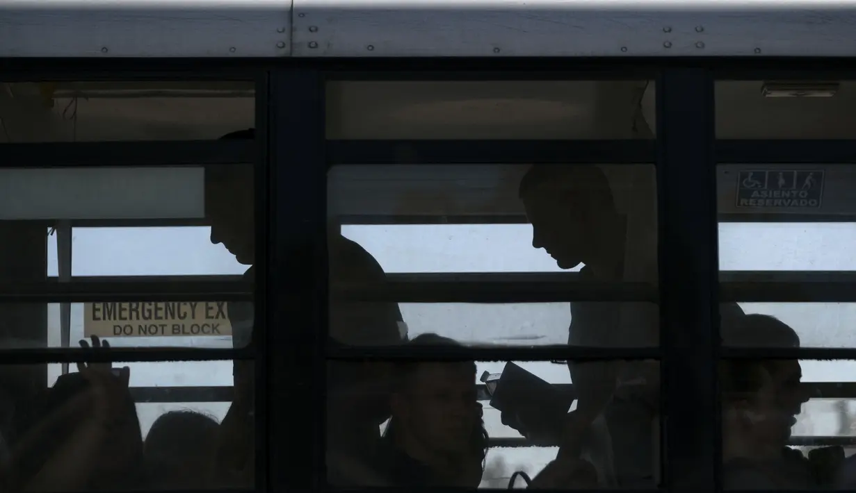 Warga Ukraina yang mencari suaka di Amerika Serikat terlihat di dalam bus yang membawa mereka ke perbatasan di kompleks olahraga Benito Juarez di Tijuana, negara bagian Baja California, Meksiko (8/4/2022). (AFP/Guillermo Arias)