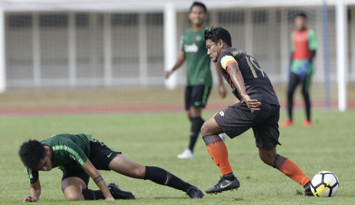 Gelandang Timnas Indonesia U-23, Mahir Radja, terjatuh saat melawan Semen Padang pada laga ujicoba di Stadion Madya, Jakarta, Selasa (12/3). Keduanya bermain imbang 2-2. (Bola.com/Vitalis Yogi Trisna)