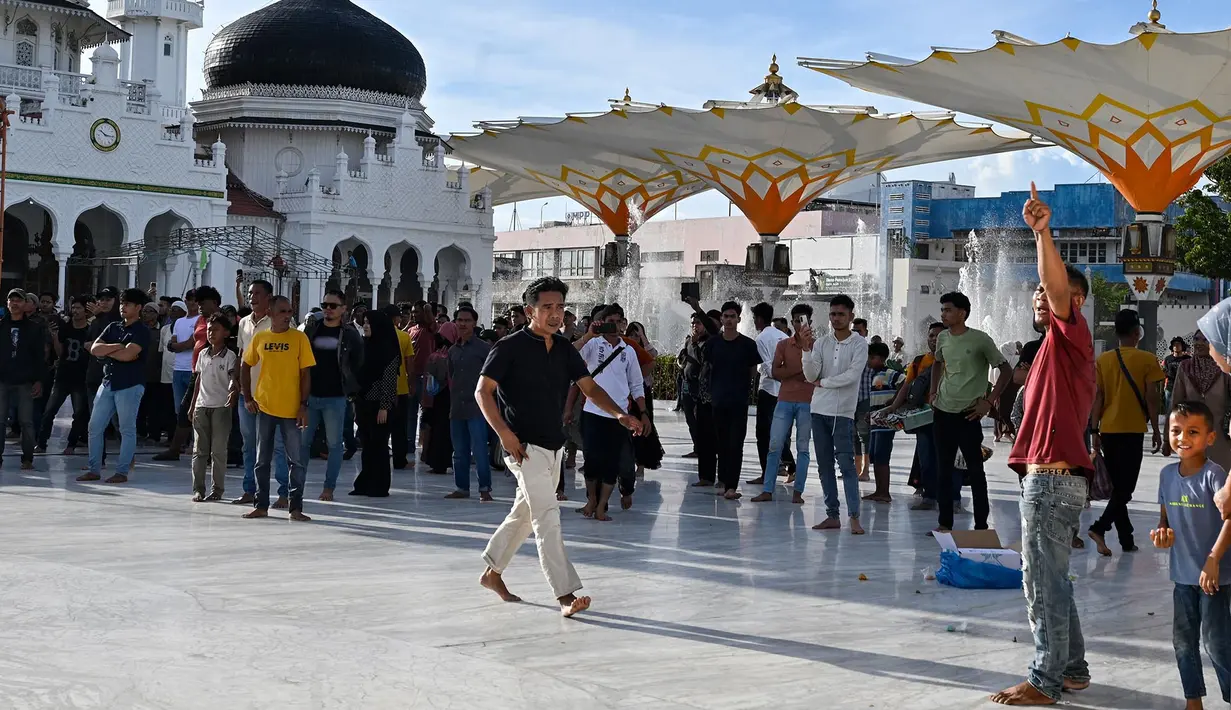 Para pengunjuk rasa yang marah meneriaki tentara saat mereka menurunkan bendera Gerakan Aceh Merdeka (GAM) yang dikibarkan berdampingan dengan bendera nasional Indonesia dalam sebuah unjuk rasa di Masjid Raya Baiturrahman, Banda Aceh, Sabtu, 15 September 2026. (AFP/ Chaideer Mahyuddin)