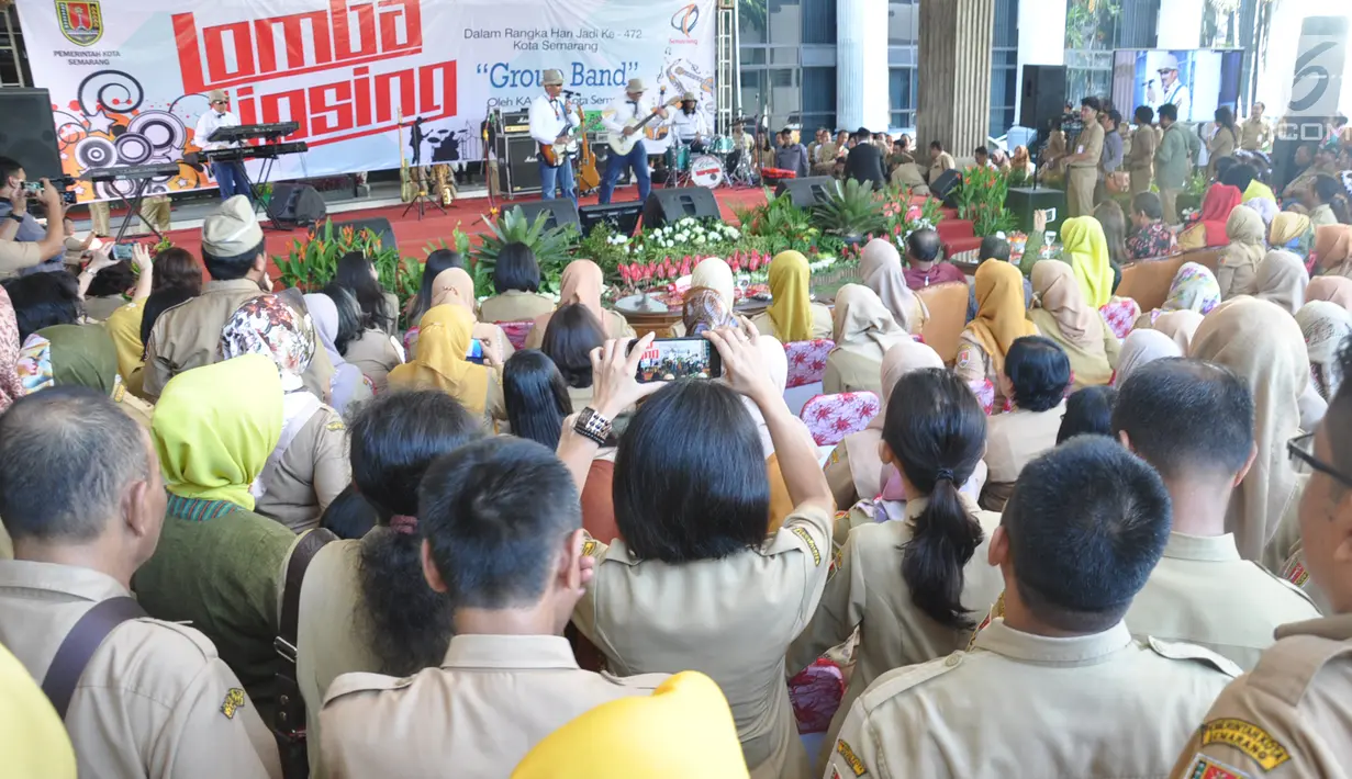 Sejumlah ASN mengambil gambar rekannya yang mengikuti lomba bernyanyi dengan lipsync di  Halaman Balai Kota Semarang, Senin ( 22/4). Acara yang diikuti oleh sepuluh kelompok dari gabungan ASN yang bekerja di Pemkot Semarang ini turut menyemarakkan HUT Kota Semarang ke-472.  (Liputan6.com/Gholib)