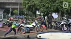 Petugas mengangkut motor berknalpot bising saat razia di kawasan Monas, Jakarta, Minggu (7/3/2021). Direktorat Lalu Lintas Polda Metro Jaya mengeluarkan kebijakan larangan kendaraan bermotor berknalpot bising melintas di kawasan Monas pada hari Sabtu dan Minggu. (Liputan6.com/Herman Zakharia)