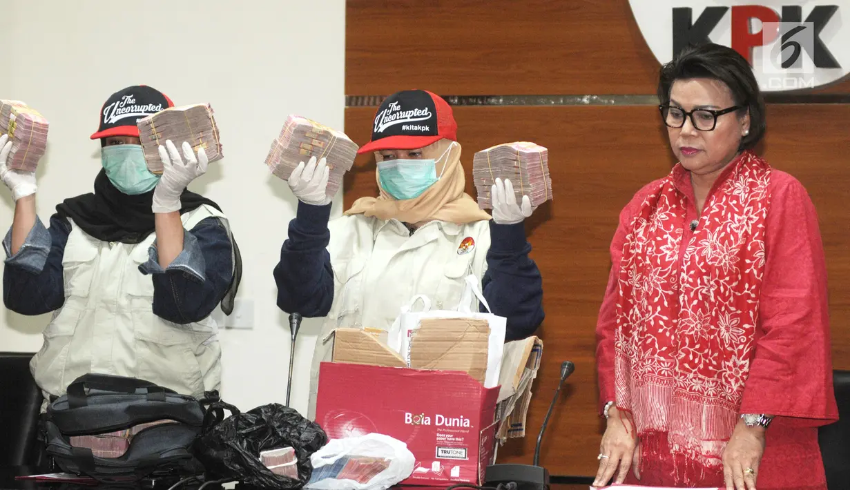 Wakil Pimpinan KPK, Basaria Panjaitan (kanan) dan penyidik menunjukan barang bukti uang Rp1,5 milyar di gedung KPK, Jakarta, Rabu (12/12). KPK menetapkan 4 tersangka terkait dugaan suap anggaran pendidikan di Cianjur. (merdeka.com/Dwi Narwoko)