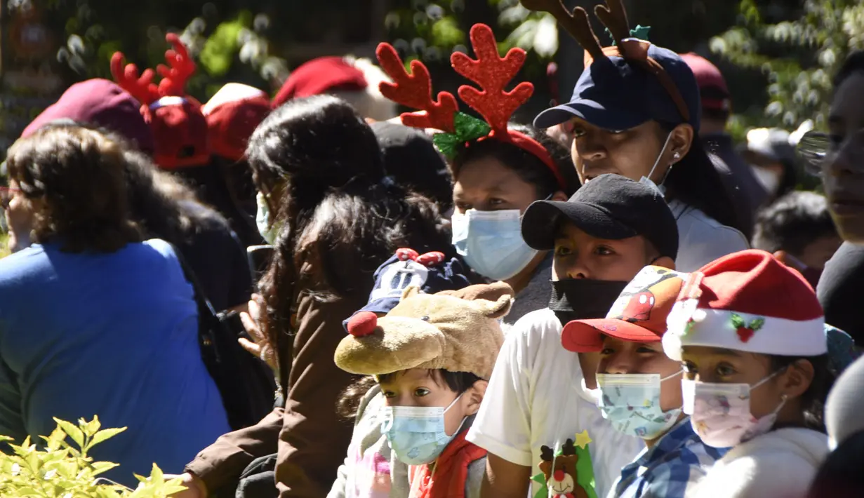 Anak-anak mengunjungi kebun binatang pada hari pemberian hadiah untuk hewan sebagai bagian dari tradisi Natal di Kebun Binatang La Aurora, Kota Guetemala, Selasa (20/12/2022). Pengunjung dapat melihat jerapah, simpanse, puma, lemur, dan anjing afrika selama kegiatan tahun ini. (Orlando ESTRADA / AFP)