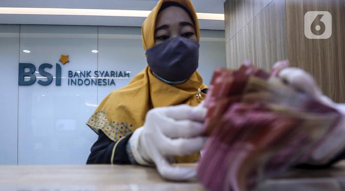 Pekerja menghitung uang di kantor cabang Bank Syariah Indonesia, Jakarta Selasa (2/2/2021). PT Bank Syariah Indonesia Tbk (BSI) resmi beroperasi dengan nama baru mulai 1 Februari 2021. (Liputan6.com/Johan Tallo)
