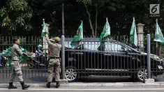 Petugas Satpol PP mencopot bendera partai politik di sepanjang pagar kawasan Pancoran, Jakarta. Selasa (18/7). Pencopotan dilakukan untuk menertibkan bendera partai politik liar yang memenuhi ruang publik di Ibukota. (Liputan6.com/Immanuel Antonius)