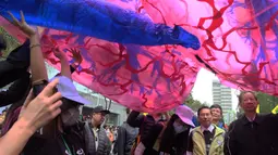Para pengunjuk rasa membawa paru-paru buatan selama demonstrasi menuntut pemerintah Taiwan dalam pengurangan polusi udara di Taipei (26/12). Ratusan warga berbaris di jalan-jalan memprotes kebijakan energi pemerintah. (AFP PHOTO/Sam Yeh)