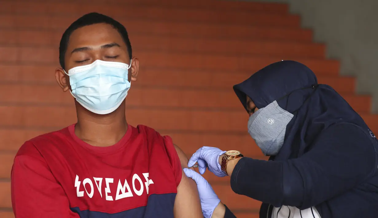 Warga menerima suntikan vaksin virus corona COVID-19 Sinovac di Stadion Patriot Candrabhaga, Bekasi, Kamis (28/10/2021). Indonesia melihat ke depan dengan waspada akan gelombang ketiga COVID-19 selama perjalanan liburan yang akan datang. (AP Photo/Achmad Ibrahim)