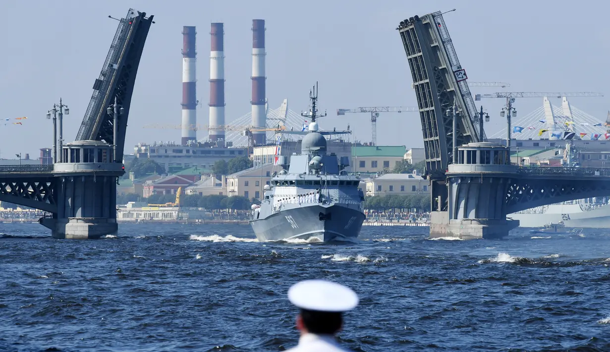 Seorang pelaut menyaksikan kapal perang Rusia berlayar selama parade Hari Angkatan Laut di Sungai Neva, Saint Petersburg, Rusia, Minggu (29/7). (Kirill Kudryavtsev/AFP)