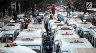 Sopir angkot trayek 44 (Jatinegara-Kampung Melayu-Tebet) melakukan unjuk rasa di sekitar Stasiun Tebet, Jakarta, Senin (12/2).  Angkot M-44 memenuhi jalan akses putaran balik di bawah flyover Tebet hingga menimbulkan kemacetan (Liputan6.com/Arya Manggala)