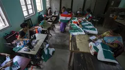 Pegawai pemerintah menjahit bendera tiga warna India di kantor menjelang Hari Kemerdekaan di Gauhati, di negara bagian timur laut Assam, Selasa, 2 Agustus 2022. Perdana Menteri India Narendra Modi telah mengimbau warga untuk mengibarkan atau memajang bendera nasional di Hari Kemerdekaan pada 15 Agustus. (AP Photo/Anupam Nath)