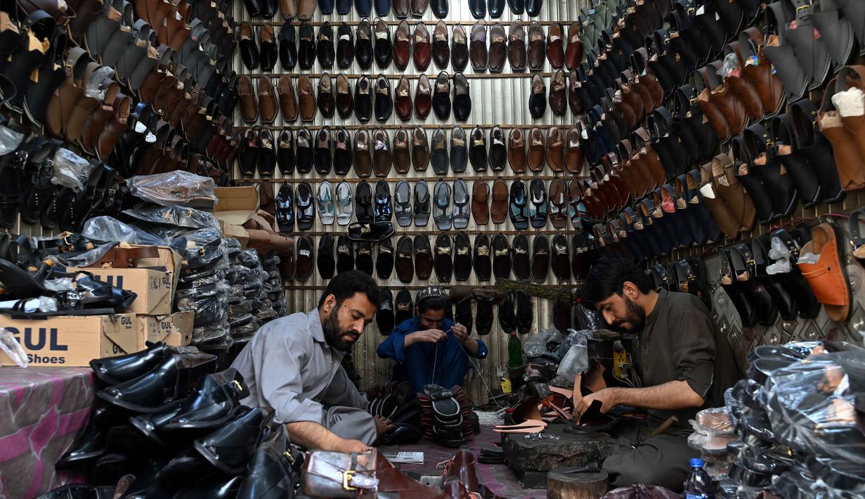 Di sisi lain, kesibukan juga terjadi di salah satu bengkel perajin sepatu tradisional di Lahore, Pakistan. Tampak dalam foto, aktivitas para perajin sepatu membuat sandal di sebuah bengkel menjelang perayaan Idul Fitri selama bulan suci Ramadan 1447 Hijriah di Lahore pada 14 Maret 2026. (Arif ALI/AFP)