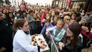 Seorang koki membagikan potongan kue cokelat atau dikenal sebagai Sacher Torte, kepada warga sekitar di Ljubljana, Slovenia, Rabu (21/9). Kue dengan diameter 3,5 meter ini diklaim menjadi Sacher Torte terbesar di dunia. (AFP PHOTO/Jure MAKOVEC)