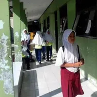 Seorang siswi SMP tak mampu beli seragam putih-biru. Dia terpaksa ke sekolah pakai seragam SD dan sandal jepit. | Sumber Foto: Liputan6.com