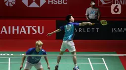 Pebulu tangkis ganda putra Indonesia Kevin Sanjaya/Marcus Gideon saat melawan pebulu tangkis ganda putra China Liu Yu Chen/Ou Xuan Yi pada babak 16 besar turnamen Daihatsu Indonesia Masters 2023 di Istora Senayan, Jakarta, Kamis (26/1/2023). The Minions gagal lolos ke babak selanjutnya karena memutuskan untuk mundur atau retired pada set ketiga akibat cedera yang dialami Marcus Gideon saat ganda China unggul dengan skor 19 - 21, 21-8, dan 11-6. (Liputa6.com/Herman Zakharia)