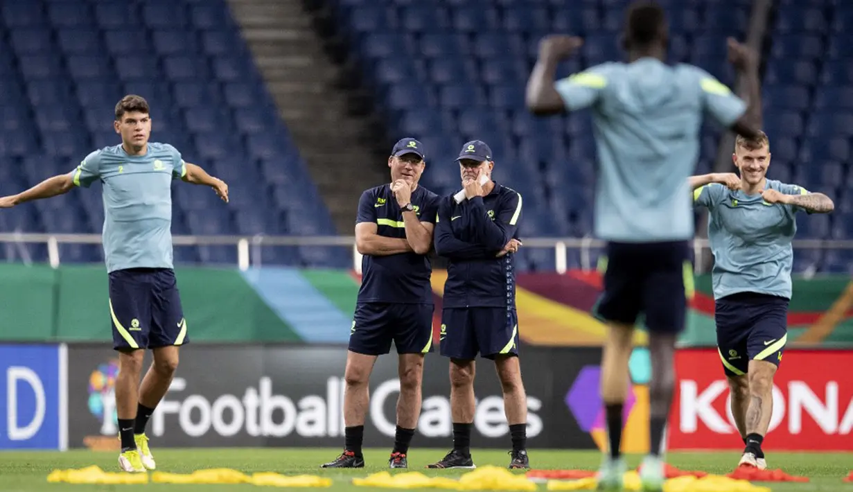 Pelatih Australia Graham Arnold (tengah kanan) berbicara dengan seorang anggota tim saat sesi latihan di Stadion Saitama, Saitama, Jepang, Senin (11/10/2021). Australia akan menghadapi Jepang pada pertandingan kualifikasi Piala Dunia 2022. (CHARLY TRIBALLEAU/AFP)