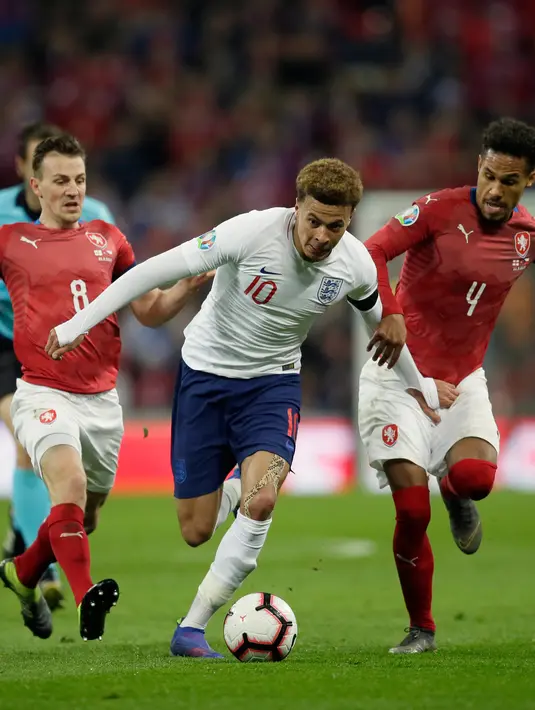 Gelandang Inggris, Dele Alli (tengah) menggiring bola dari kawalan dua pemain Republik Ceko selama pertandingan grup A babak kualifikasi Euro 2020 di stadion Wembley di London (22/3). Inggris menang telak atas Ceko 5-0. (AP Photo/Tim Irlandia)
