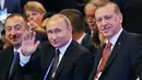 Presiden Rusia Vladimir Putin bersama Presiden Turki Recep Tayyip Erdogan tersenyum kepada awak media Putin saat menghadiri 23rd World Energy Conress, Istanbul, Turki (10/10). (AP Photo/Emrah Gurel)