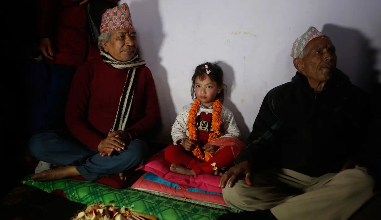Gadis berusia lima tahun yang bernama Nihira Bajracharya (tengah) diapit oleh pendeta Hindu setelah dia ditunjuk sebagai Dewi Hidup baru yang dikenal Kumari di sebuah kuil Hindu di Patan, Lalitpur, Nepal (5/2). (AP Photo / Niranjan Shrestha)