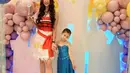 Aura Kasih menjelma menjadi Princess Moana mengenakan mini dress nuansa merah-putih. Sedangkan si kecil Arabella berdandan ala Princess Elsa dengan mengenakan dress warna biru. [@aurakasih]