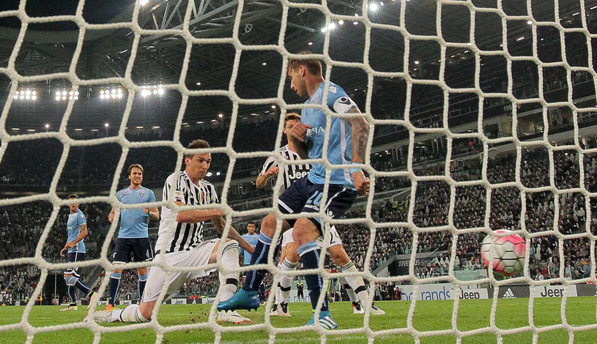 Striker Juventus, Mario Mandzukic, mencetak gol ke gawang Lazio pada lanjutan Serie A di Stadion Juventus, Turin, Kamis (21/4/2016) dini hari WIB. (AFP/Marco Bertorello)