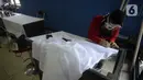 Ibu rumah tangga menyelesaikan pembuatan batik kembang mayang di Kampung Batik, Kelurahan Larangan Selatan, Kota Tangerang, Banten, Rabu (26/8/2020). Di tempat yang menjadi destinasi wisata tersebut kita bisa melihat langsung pembuatan dan mengikuti pelatihan membatik. (merdeka.com/Dwi Narwoko)