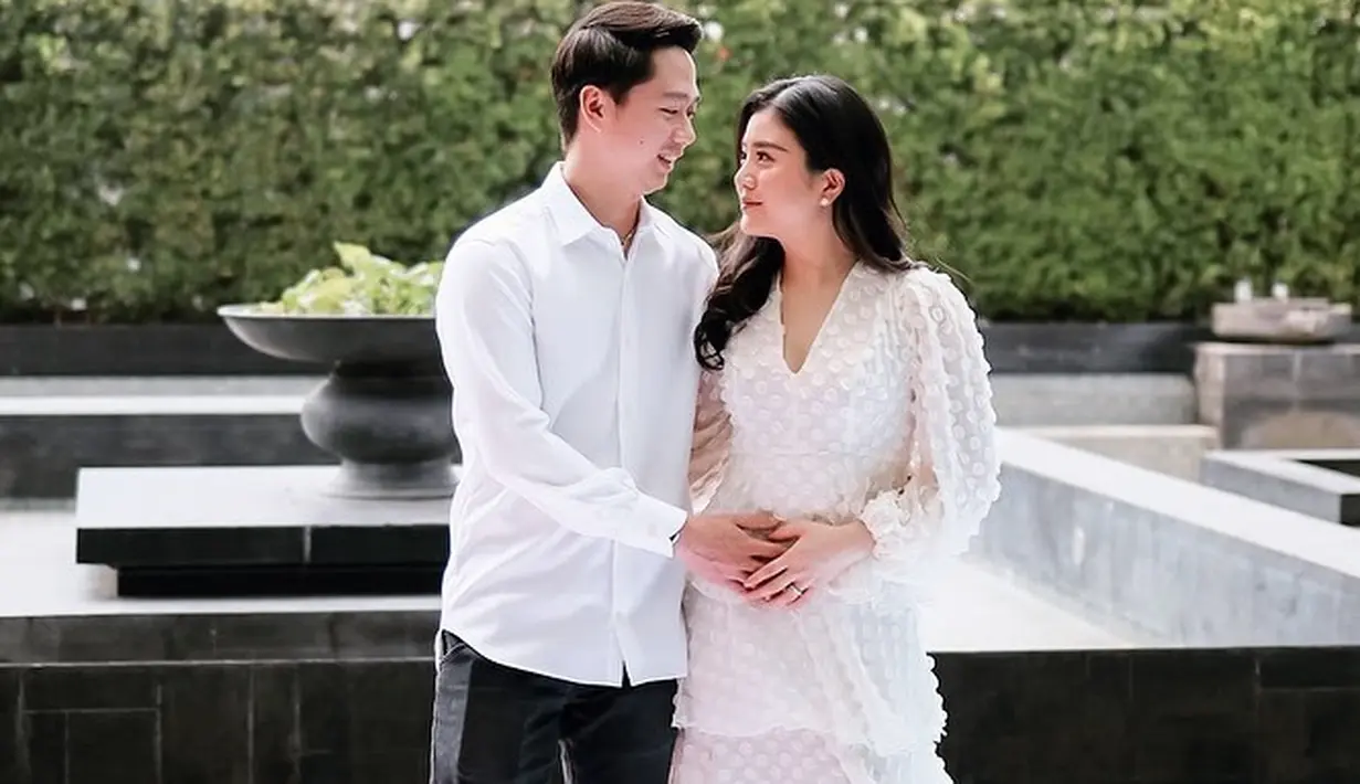 Ini adalah momen gender reveal yang dilakukan Valencia dan Kevin. Keduanya tampil serasi mengenakan outfit berwarna putih. Valencia tampil memukau dengan dress putih lengan panjang yang cantik. [Foto: Instagram/valenciatanoe]