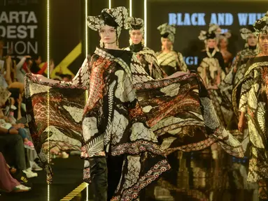 Model mengenakan busana rancangan desainer Sugeng Waskito dengan brand Gee Batik pada hari ketiga Jakarta Modest Fashion Week di Gandaria City, Jakarta, Sabtu (28/7). Gee Batik menampilkan 10 looks tema hitam dan putih. (Kapanlagi.com/Bayu Herdianto)