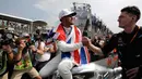 Lewis Hamilton bersalaman dengan salah satu kru timnya saat merayakan kemenangan meraih juara dunia F1 di Autodromo Hermanos Rodrigue, Meksiko (29/10).  Hamilton meraih juara F1 untuk ke empat kalinya. (AP Photo / Moises Castillo)