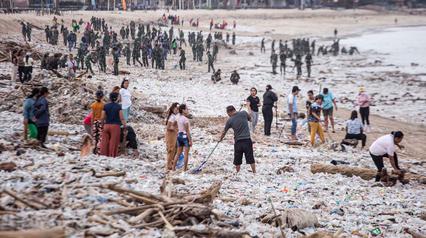 Para pekerja dan warga membersihkan ceceran dan tumpukan sampah plastik yang terdampar di Pantai Jimbaran, Bali, pada Selasa 10 Maret 2026. Pantai Jimbaran, Bali, kembali dipenuhi sampah kiriman. (Lana Priatna/AFP)