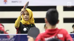 Petenis meja difabel Indonesia, Leli Marlina memukul bola ke arah Bee Tin Toh (Singapura) pada Indonesia Para Games Invitational Tournament 2018 di GBK Arena, Jakarta, Minggu (1/7). Leli Marlina unggul tiga set langsung. (Liputan6.com/Helmi Fithriansyah)