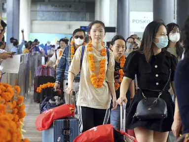Wisatawan mancanegara (wisman) asal China tiba di bandara internasional Ngurah Rai di Bali, Minggu (22/1/2023). Penerbangan langsung turis China mendarat di pulau Bali untuk pertama kalinya pada hari Minggu dalam hampir tiga tahun setelah ditutupnya rute penerbangan lantaran kebijakan nol Covid-19. (AP Photo/Firdia Lisnawati)