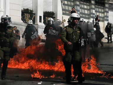 Sejumlah polisi anti huru-hara melawan aksi demonstran yang melemparkan bom api di Athena, Yunani, (12/11/2015). Para Demonstran memprotes langkah-langkah penghematan yang diminta oleh badan pinjaman internasional. (REUTERS/Alkis Konstantinidis)