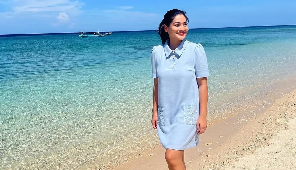 Mengaku tidak membawa baju renang, istri Christian Sugiono ini justru menuai banyak pujian karena tetap berpenampilan sopan saat berkunjung ke pantai. Titi Kamal tetap anggun dengan summer dress yang dikenakannya. (Liputan6.com/IG/@titi_kamall)