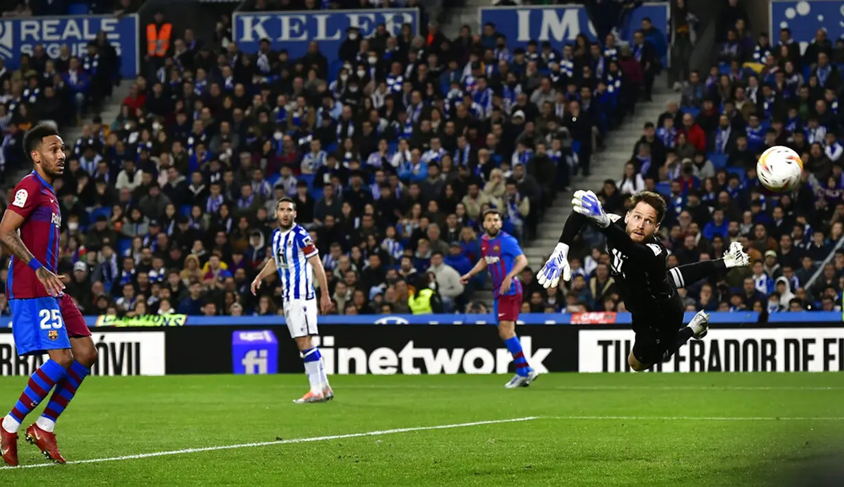 <p>Pemain Barcelona Pierre-Emerick Aubameyang (kiri) mencoba mencetak gol di sebelah kiper Real Sociedad Alex Remiro pada pertandingan Liga Spanyol di Reale Arena Stadium, San Sebastian, Spanyol, 21 April 2022. Barcelona menang 1-0. (AP Photo/Alvaro Barrientos)</p>
