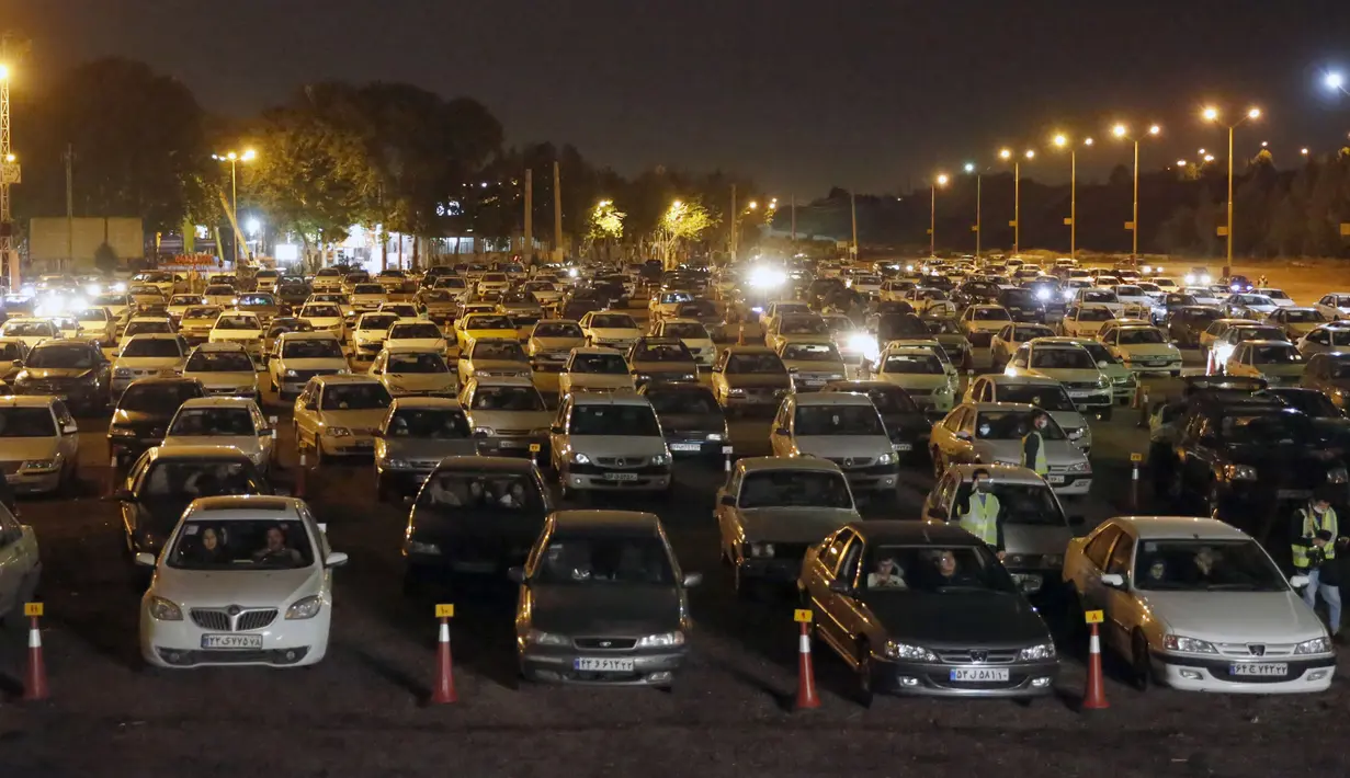 Warga duduk dalam mobil-mobil saat upacara keagamaan pada bulan suci Ramadan di tengah pandemi COVID-19, Teheran, Iran, Kamis (30/4/2020). Keluarga-keluarga di Iran menghadiri upacara keagamaan drive-in karena tidak memiliki kesempatan untuk salat di masjid setelah berbuka puasa. (STR/AFP)