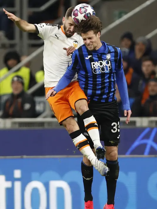 Bek Atalanta, Hans Hateboer berebut bola udara dengan bek Valencia, Eliaquim Mangala pada pertandingan leg pertama babak 16 besar Liga Champions di stadion San Siro di Milan, Italia, Rabu, (19/2/2020). Atalanta menang telak atas Valencia 4-1.  (AP Photo/Antonio Calanni)
