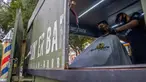 Seorang tukang cukur memotong rambut pelanggan di mobil van atau truck yang diubah menjadi barbershop di sebuah jalan di tengah pandemi virus corona COVID-19, di Mexico City, pada Minggu (6/9/2020). (Photo by CLAUDIO CRUZ / AFP)