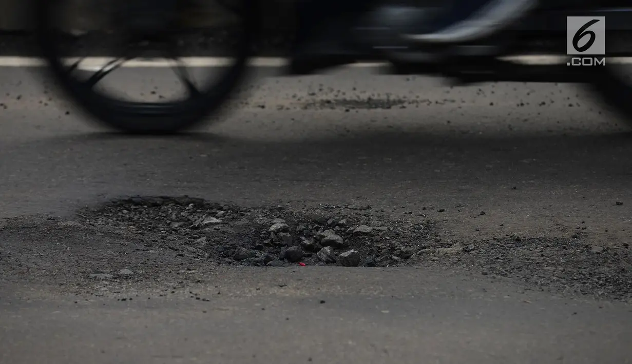 Kondisi jalan berlubang di Jalan Gunung Sahari, Jakarta, Selasa (9/4). Meskipun sudah dilakukan penambalan, jalan raya tersebut sering rusak akibat beban kendaraan yang melintas di atasnya dan intensitas hujan yang belakangan ini cukup tinggi. (merdeka.com/Imam Buhori)