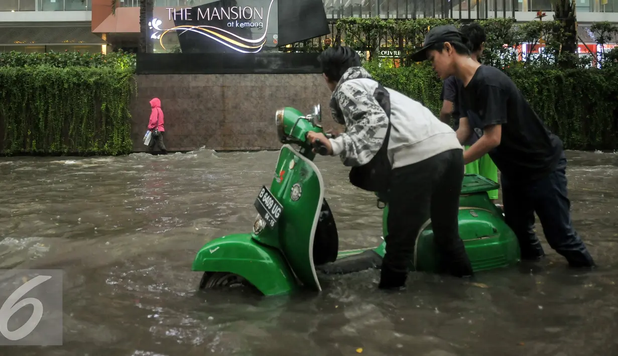 Pengendara mendorong motornya yang mogok akibat menerebos banjir di Jalan Kemang Raya, Jakarta, Jumat (11/11). Hujan deras yang mengguyur wilayah Jakarta menyebabkan banjir di kawasan Jalan Kemang Raya. (Liputan6.com/Yoppy Renato)