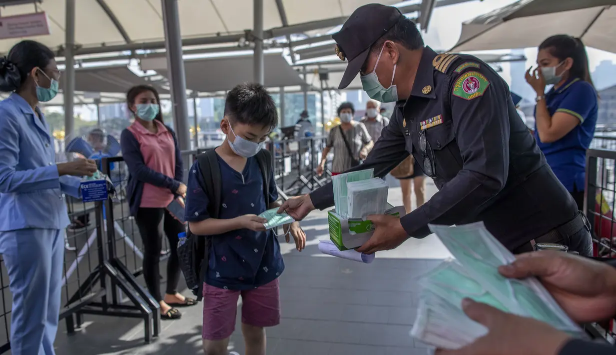 Petugas memberikan masker pelindung untuk pengunjung di sebuah mal mewah di Bangkok, Thailand  (28/1/2020). Ketakutan terhadap virus corona dari China membuat persediaan masker semakin menipis di beberapa pusat penjualan. (AP Photo/Gemunu Amarasinghe)