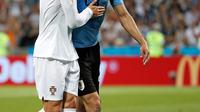 Penyerang Portugal, Cristiano Ronaldo memapah Penyerang Uruguay, Edinson Cavani yang Cedera keluar lapangan saat pertandingan babak 16 besar Piala Dunia 2018 di Stadion Fisht di Sochi, Rusia (30/6).  (AP Photo/Francisco Seco)