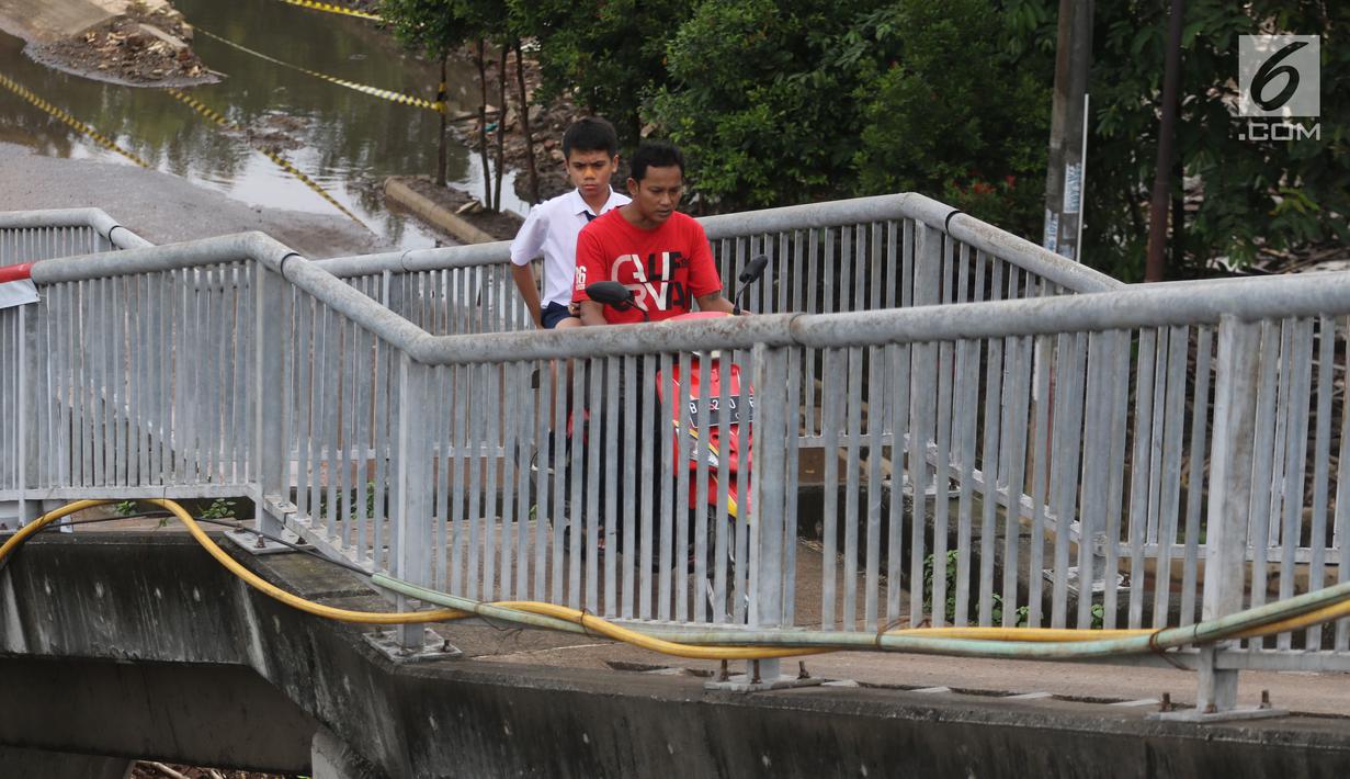 Pengendara motor menaiki Jembatan Penyeberangan Orang (JPO) di kawasan Cikunir, Bekasi Barat, Senin (12/3). Pengendara nekat melintasi JPO untuk mempersingkat jarak tempuh dan menghindari kemacetan. (Liputan6.com/Arya Manggala)