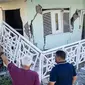 Orang-orang melewati sebuah rumah yang rusak oleh gempa bumi di Guanica, Puerto Rico. (source: AFP/Ricardo Arduengo)