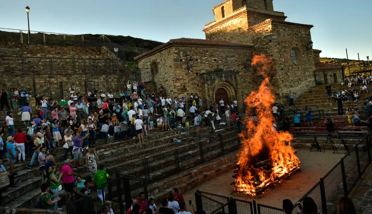 Warga membakar kayu sebelum perayaan malam San Juan di San Pedro Manrique, Spanyol Utara, Minggu (24/6). Tradisi kuno Spanyol ini diperingati untuk menyambut musim panas. (AP Photo/Alvaro Barrientos)
